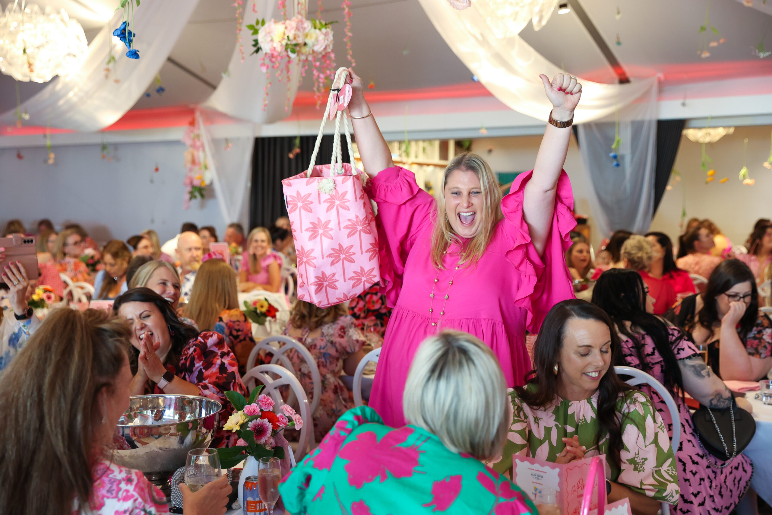 Woman in pink dress celebrating her Go Pink Day raffle win