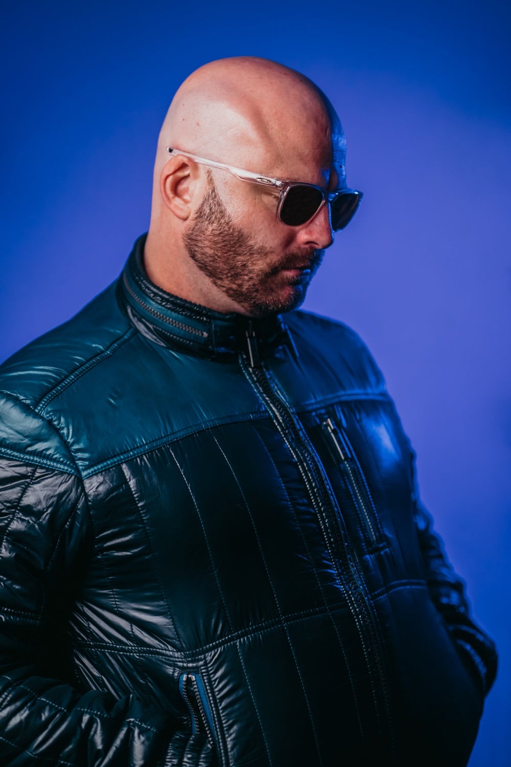 Dr Bazil wearing a leather jacket on blue backdrop